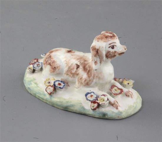 A rare Derby figure of a recumbent spaniel, c.1758-60, l. 9cm, several flowers restored